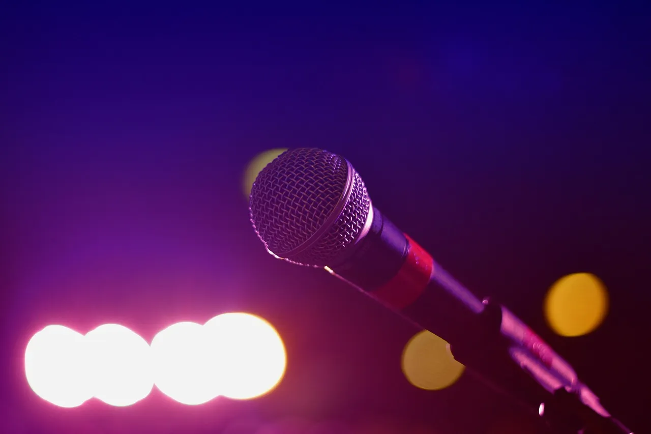A microphone in front of colorful stage lights