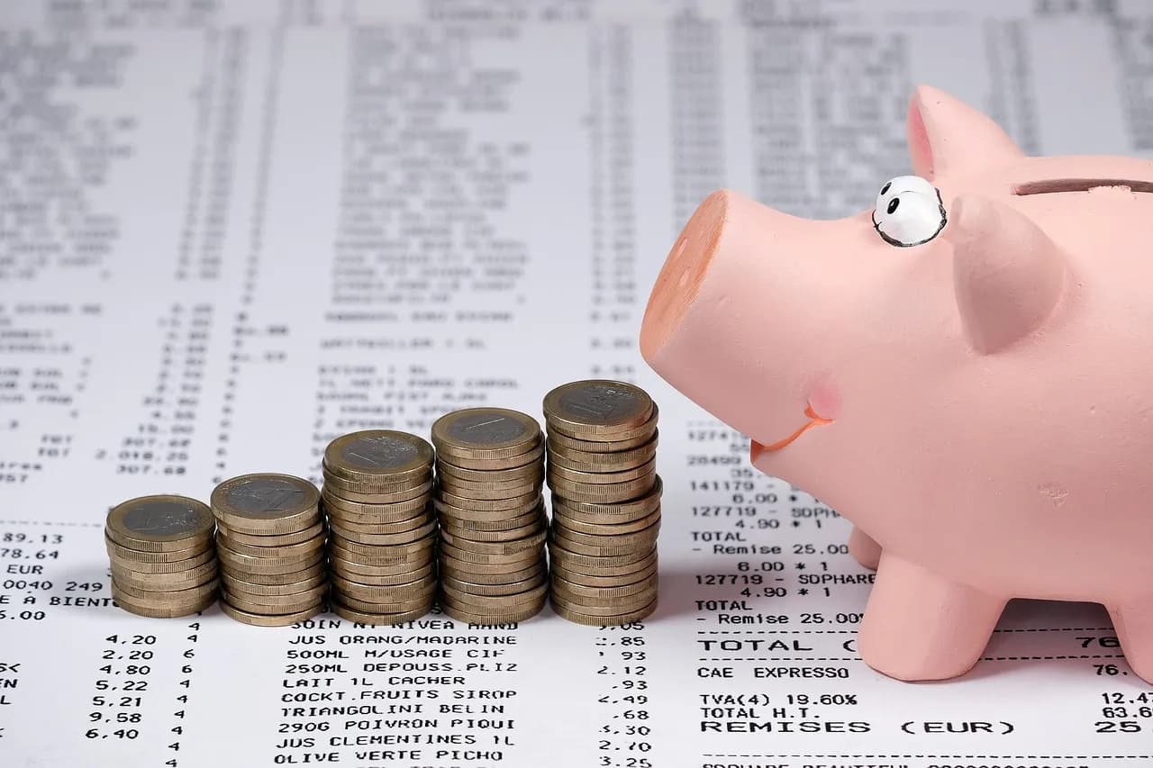 A piggy bank beside stacks of coins
