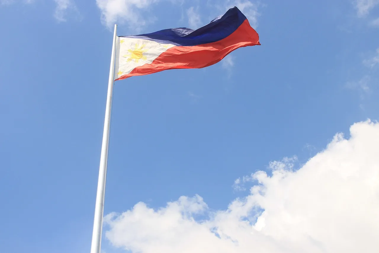The Philippine flag waving against a blue sky