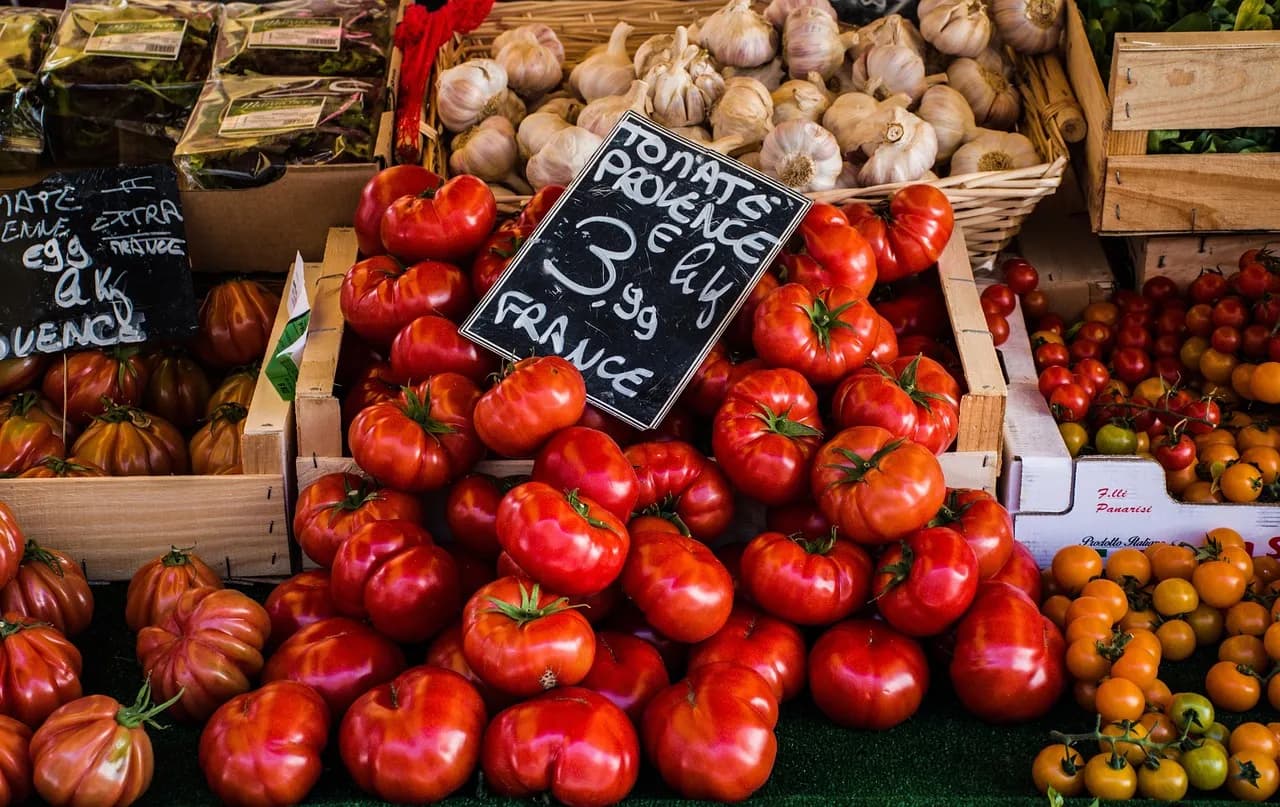 Tomatoes and vegetables with price tags at a market