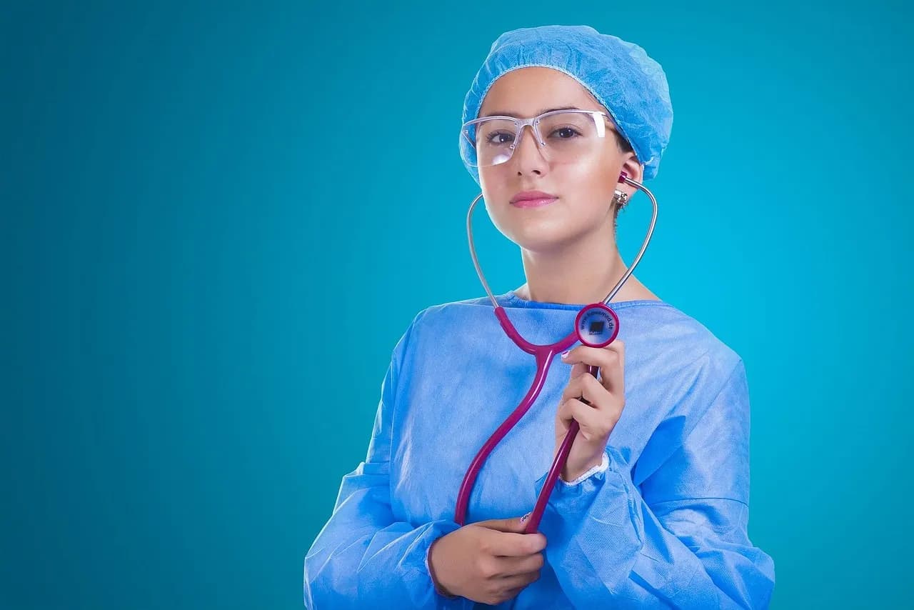 A young doctor in scrubs holding a stethoscope